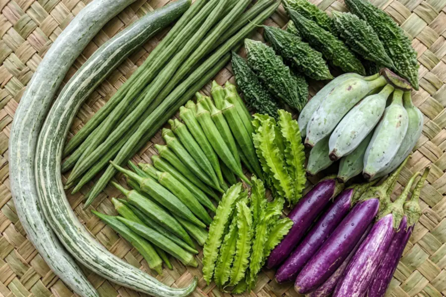 Snake gourds, drumstick pods, okra, winged beans, bitter gourds, ash plantains and purple and white-streaked brinjals together on a woven palm-leaf mat
